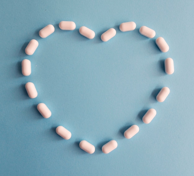 Photo pills on a heart shape on a blue background