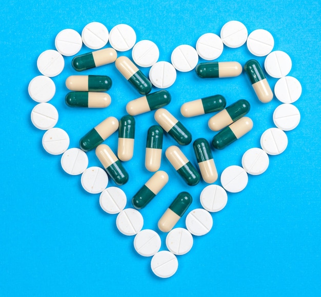 Pills in heart shaped on blue background