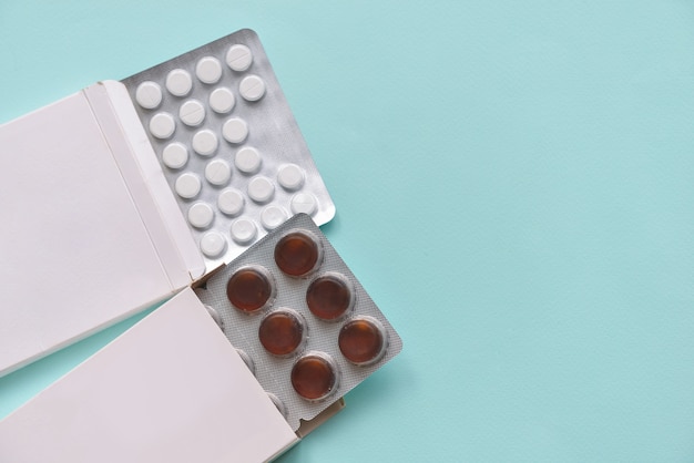 Pills medication pills in paper boxes on an isolated blue background