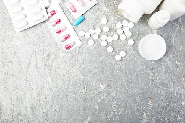 Pills. Medicine Pills in blister pack on grey background. Tablets and bottle. Copy space