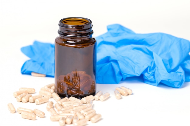 Pills near a glass container