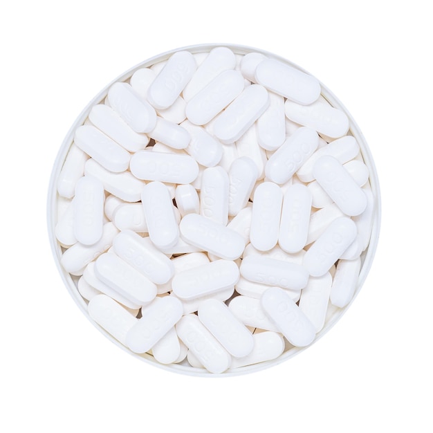 Pillole nel tappo del flacone della pillola isolati su sfondo bianco