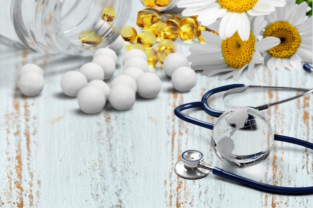 Pills spilling out of a pill bottle next to stethoscope