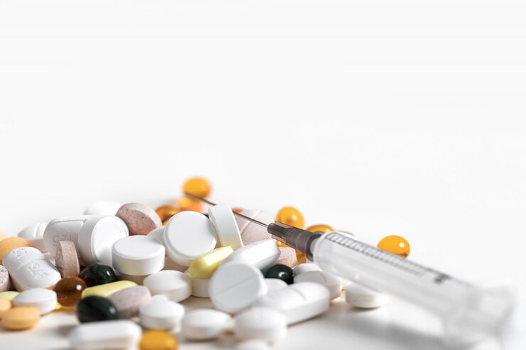 Pills and and syringe on blue