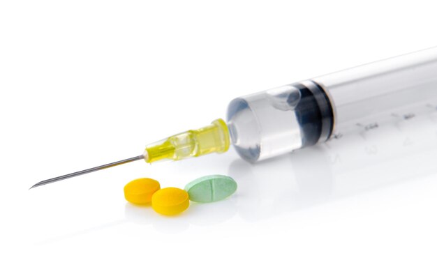 Photo pills and syringe with liquid isolated on white background