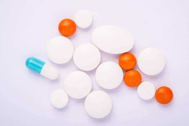 Таблетки и таблетки на ярком белом фоне, здравоохранение медицинская концепция, антибиотики и лечение, вид сверху