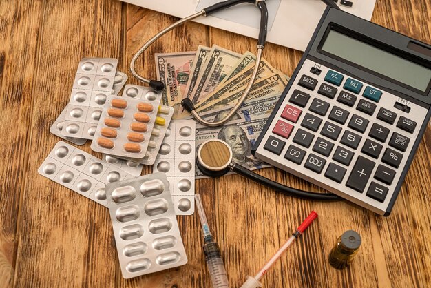 Pills with banknotes dollars stethoscope syringe arranged on a new table Medicine concept