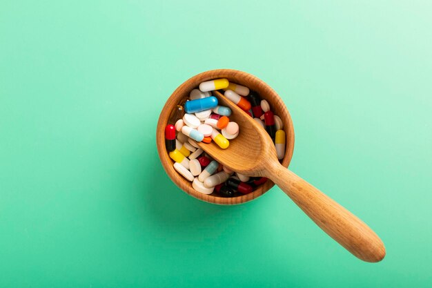 Pills in a wooden container with a spoon