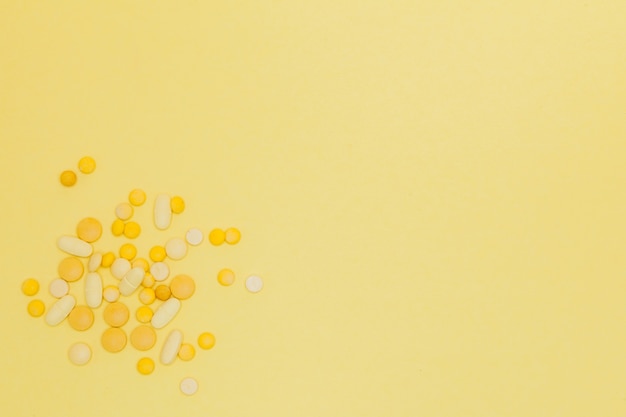 Pills on a yellow background. Design concept. Pills from a sunshine. Sunstroke. Summer diseases background. Copy space