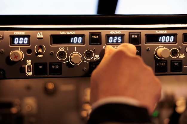 Pilot aviator fixing altitude and longitude level on dashboard in plane cockpit. Pilot pushing buttons on control panel switch, using windscreen in aircraft cabin to fly airplane. Close up.