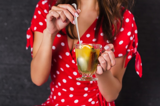 Pin-up girl met een beker met een drankje en een lepel roeren. clouse-up