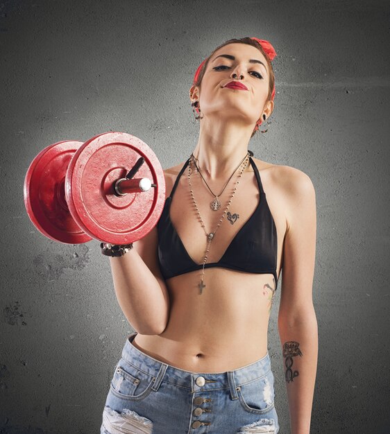 Pin-up girl with tattoo lifting a weight