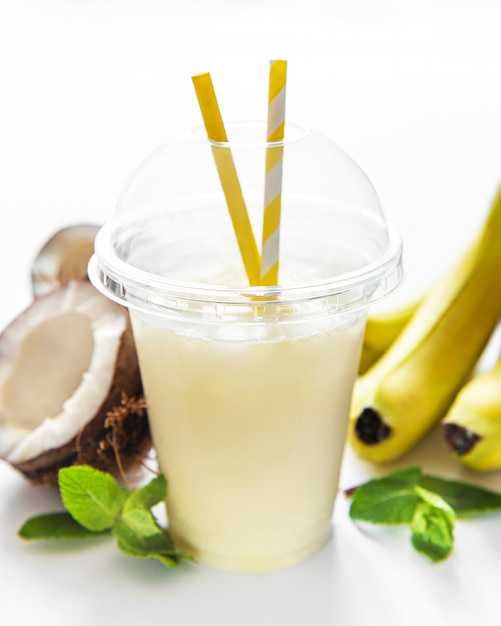 Pina colada alcoholische verse cocktail geserveerd koud met kokos en banaan op een witte achtergrond