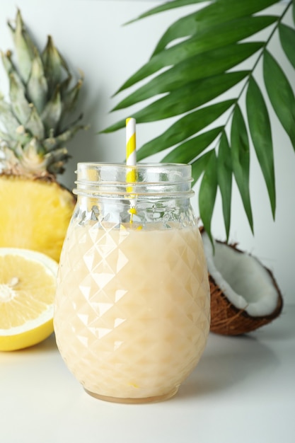 Pina colada cocktail en ingrediënten op witte tafel.