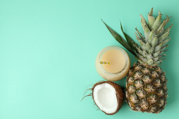 Pina colada cocktail and ingredients on mint background.