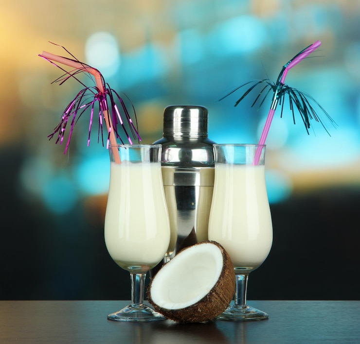 Photo pina colada drink in cocktail glasses and metal shaker on bright background