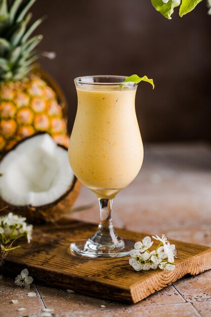 Pina colada pineapple cocktail or Lassi on a rustic wooden table