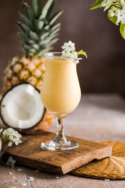 Pina colada pineapple cocktail or Lassi on a rustic wooden table