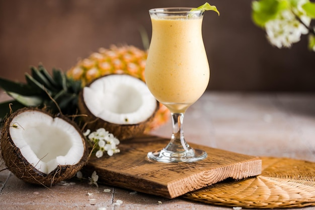 Pina colada cocktail di ananas o lassi su un tavolo in legno rustico