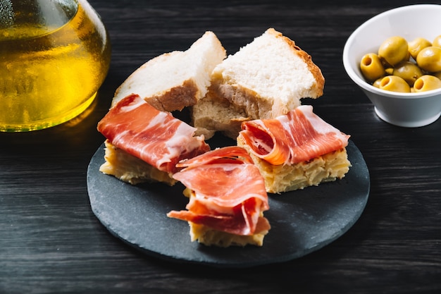 Pincho omelette and ham, with olives. In a restaurant