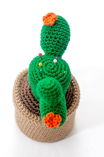 Pincushion in the shape of a cactus in a pot crocheted on a white background