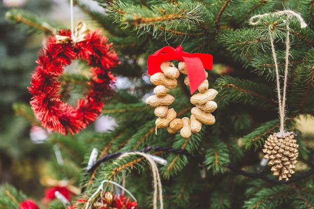 Pinda's en goud geschilderde gouden dennenappel handgemaakte decoratie op kerstboom.