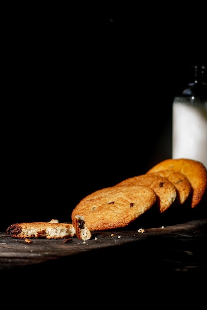 Pindakoekjes en een fles melk op een donkere achtergrond