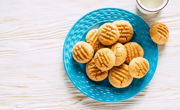 Pindakoekjes in blauw bord op witte houten achtergrond