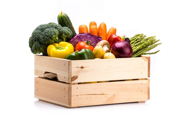 Pine box full of colorful fresh vegetables on a white background ideal for a balanced diet