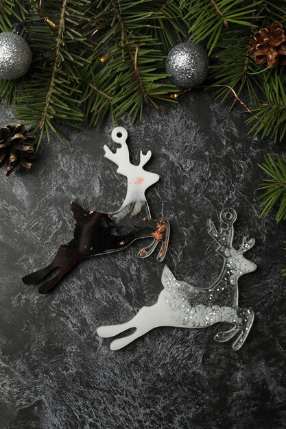 Pine branches and reindeer baubles on black smokey background