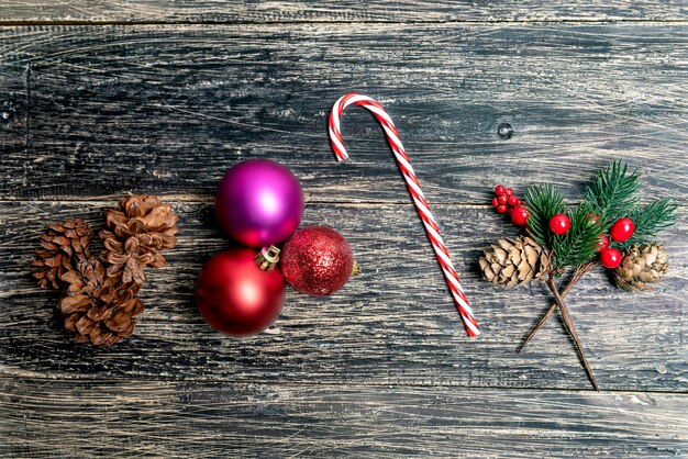 Pine Cone with a candy cane and colorful Christmas ball on wooden background. Christmas decoration