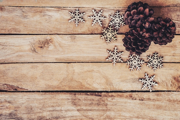 Pine cones and Snowflakes on wood  for christmas background with space.
