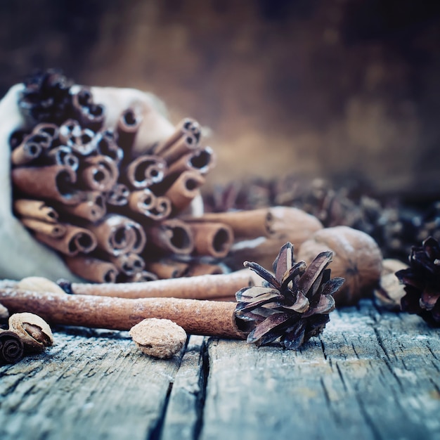 Pine cones, Sticks of Cinnamon on Wooden Background