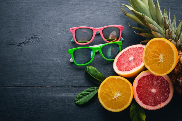 Pineapple and citrus fruits on a wooden background Tropical fruits and nuts Top view Free space for text