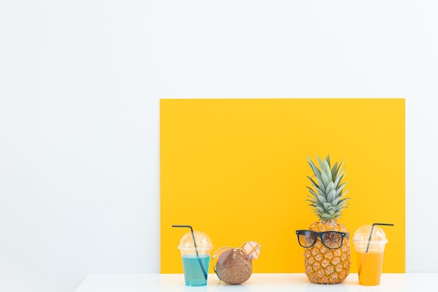 Pineapple and coconut with sunglasses resting and drink cocktail on the beach Summer vacation