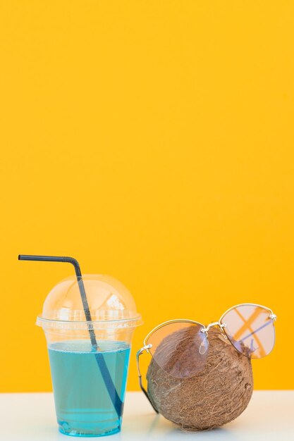 Pineapple and coconut with sunglasses resting and drink cocktail on the beach Summer vacation