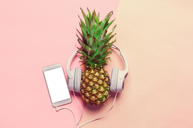 Pineapple on colored paper in headphones