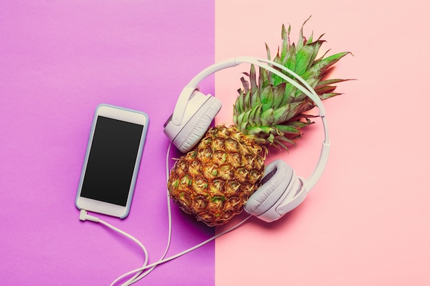 Pineapple on colored paper in headphones