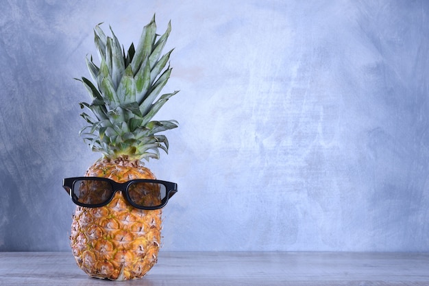 Pineapple in glasses on a wooden background.