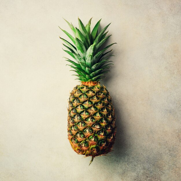 Pineapple on gray background, top view, copy space. Minimal design. Vegan and vegetarian concept. 