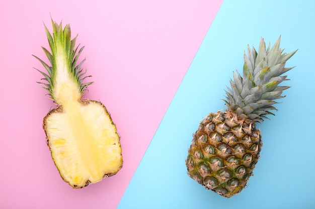 Ananas e metà dell'ananas su uno sfondo colorato