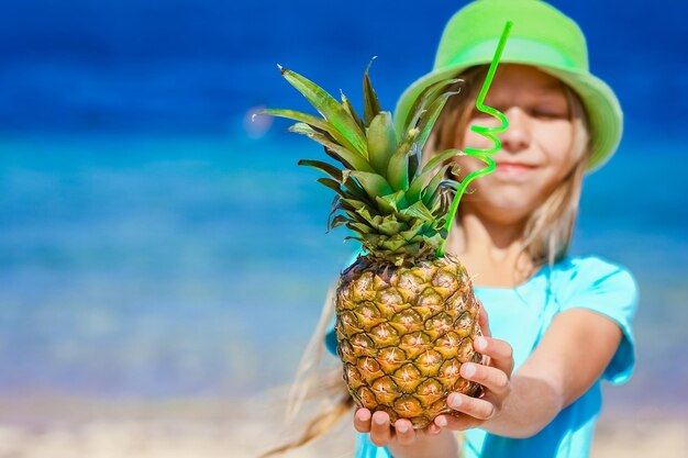 A Pineapple in the hands of a man by the sea in nature on a journey background