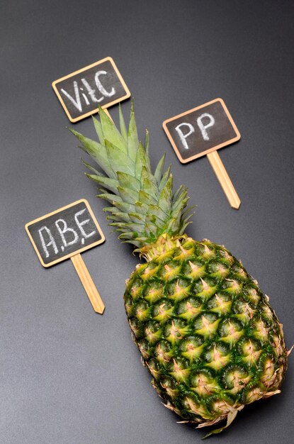 Photo pineapple and the inscriptions on the tablets with the names of the vitamins it contains