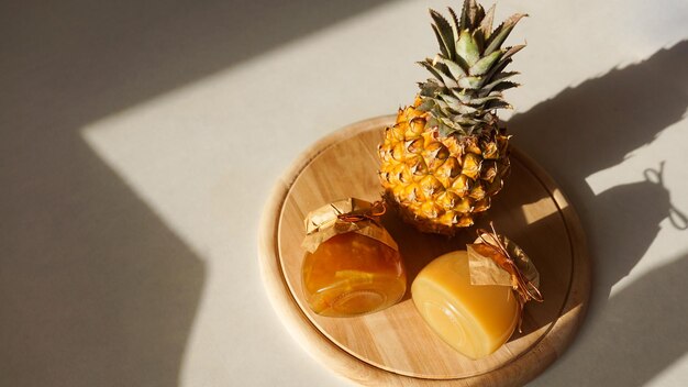 写真 ガラスの瓶にパイナップルジャムと太陽からのハードシャドウと明るい背景に新鮮なパイナップルフルーツ自家製マーマレードとコンフィチュール