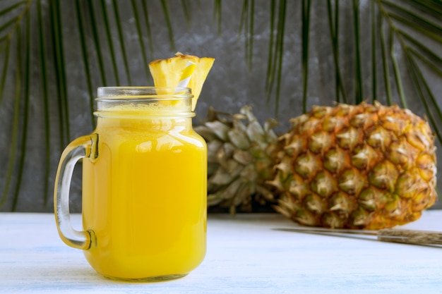 Pineapple juice in a jar with a straw.