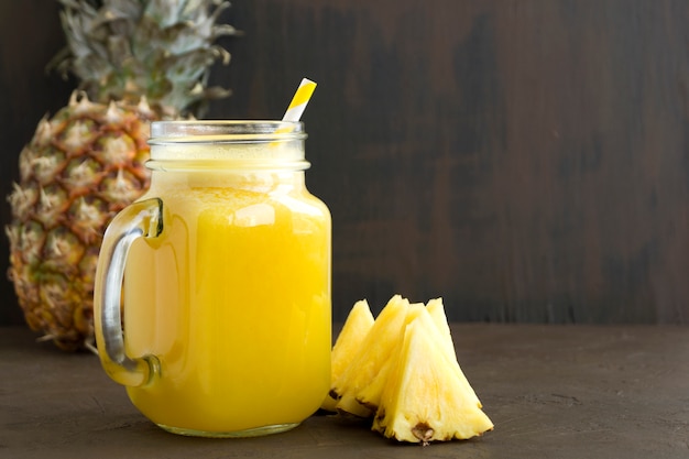 Pineapple juice in a jar with a straw.