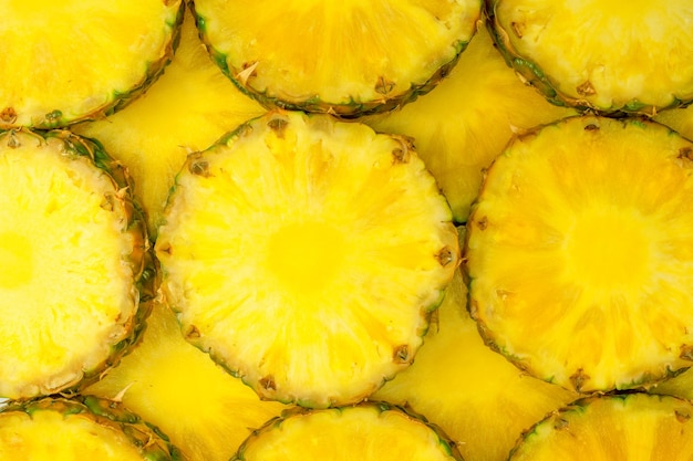 Pineapple juicy yellow slices as a background Top view