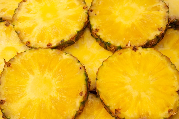 Pineapple juicy yellow slices as a background Top view