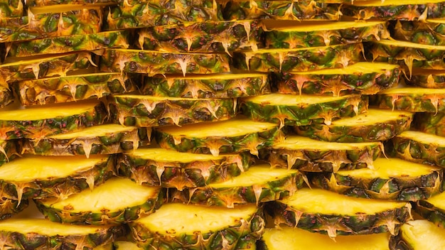 Pineapple juicy yellow slices background. Top view.