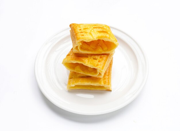 Pineapple pie in white plate on white background.